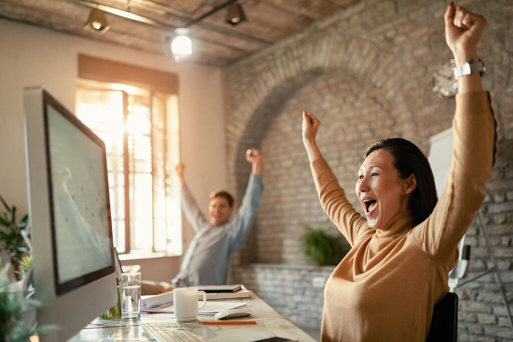 homem e mulher felizes em frente ao computador